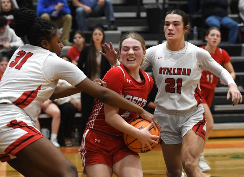 Oregon's Shaylee Davis (center) protects the ball from Stillman Valley's Dailene Wade (left) and Emma Withers (right) as she drives to the basket at the 2A Winnebago Regional on Monday, Feb. 16, 2026 at Winnebago High School.