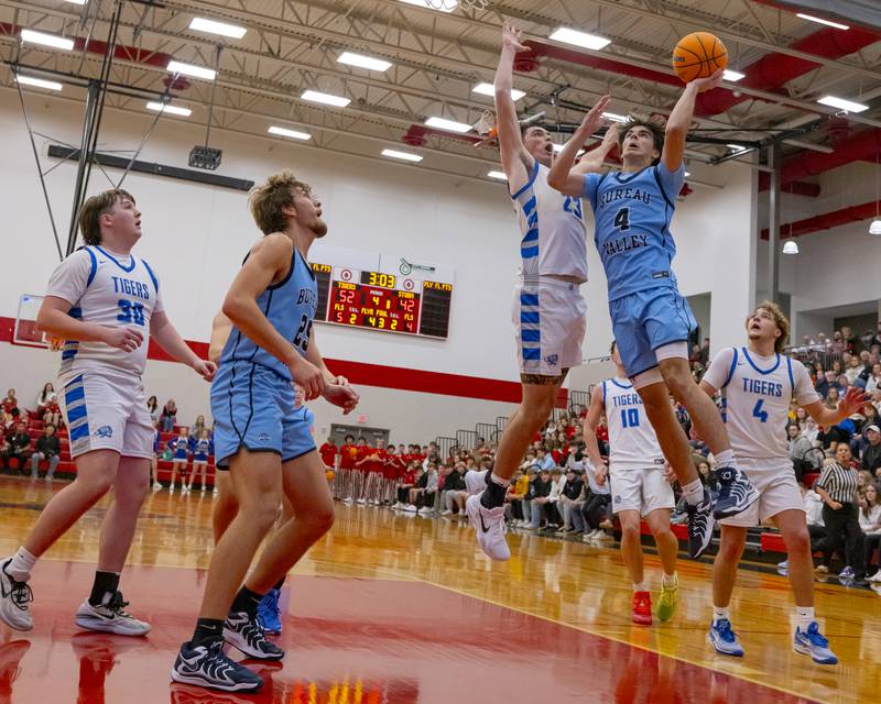 Liam Swearingen of Bureau Valley drives a layup to the basket while Princeton's Noah Laporte attempts to block during the Colmone Classic on December 7, 2024 at Hall High School.