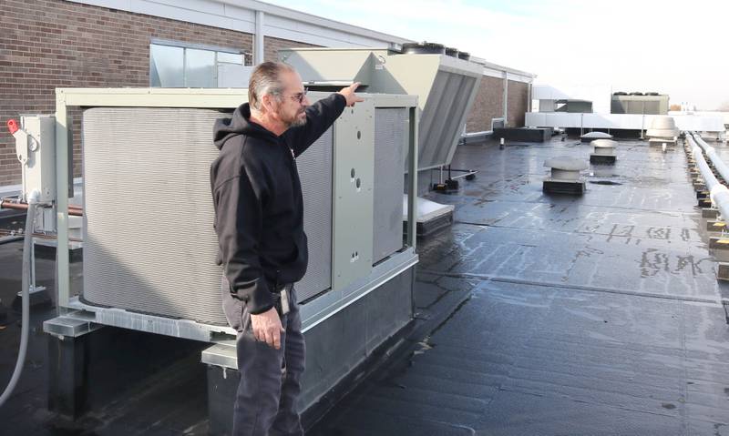 James Orr, with DeKalb School District 428 maintenance, points out two of the new air conditioning units Thursday, Nov. 3, 2022, on the roof of Huntley Middle School.