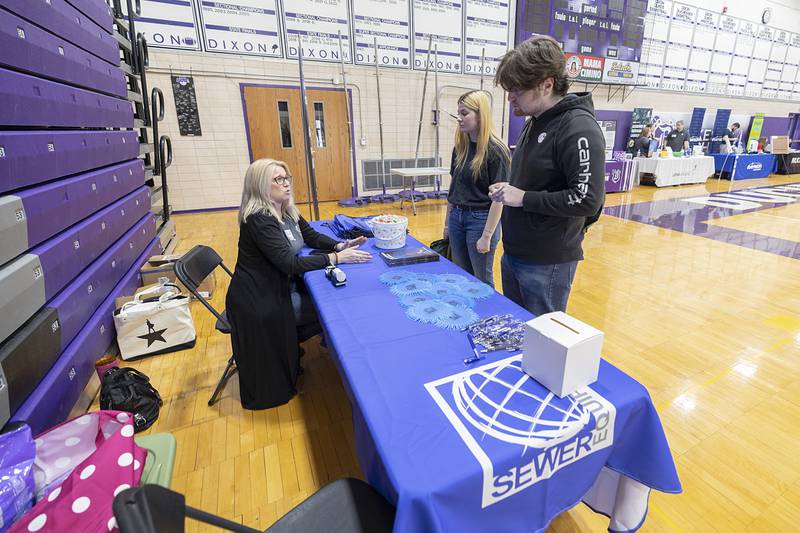 Hilary Johnson, benefits specialist at Sewer Equipment Co. of Dixon, speaks with Trinity Keener of Dixon and Mathew Call of Polo Wednesday, March 13, 2024 at the Discover Dixon career fair.