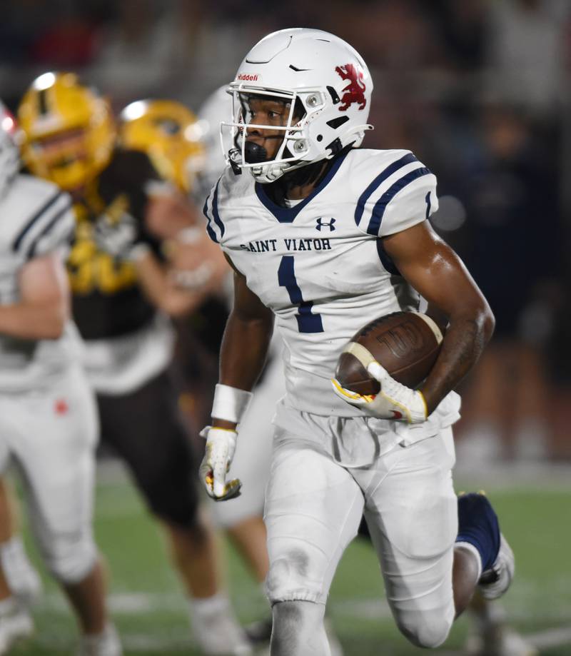 Joe Lewnard/jlewnard@dailyherald.com
St. Viator’s Dayvion Ellis carries the ball against Carmel during Friday’s game in Mundelein.