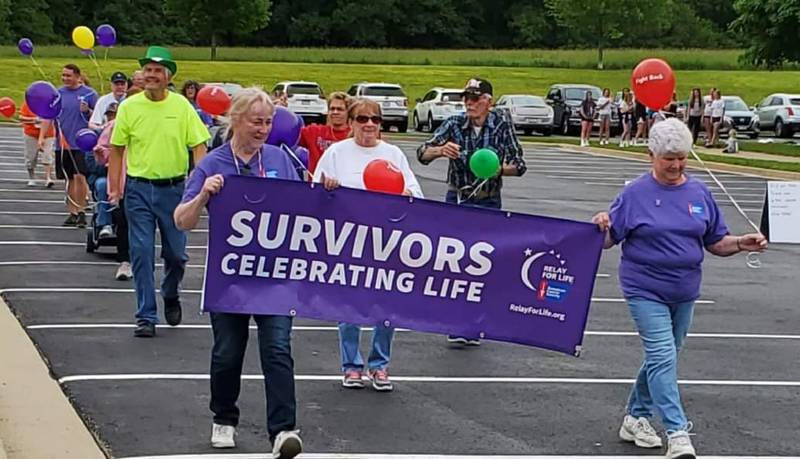 Cancer survivors and their caregivers walk the first lap to open the Relay For LIfe of Sauk Valley at Westwood Fitness and Sports Complex on Saturday, June 4.