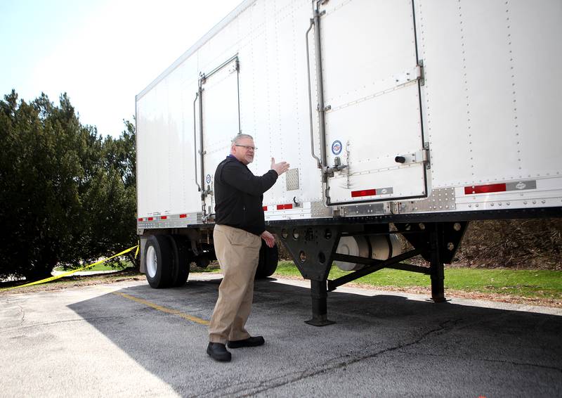 Kane County Coroner Rob Russell looks over a refrigerated trailer now parked outside the coroner's office in Geneva on April 6.