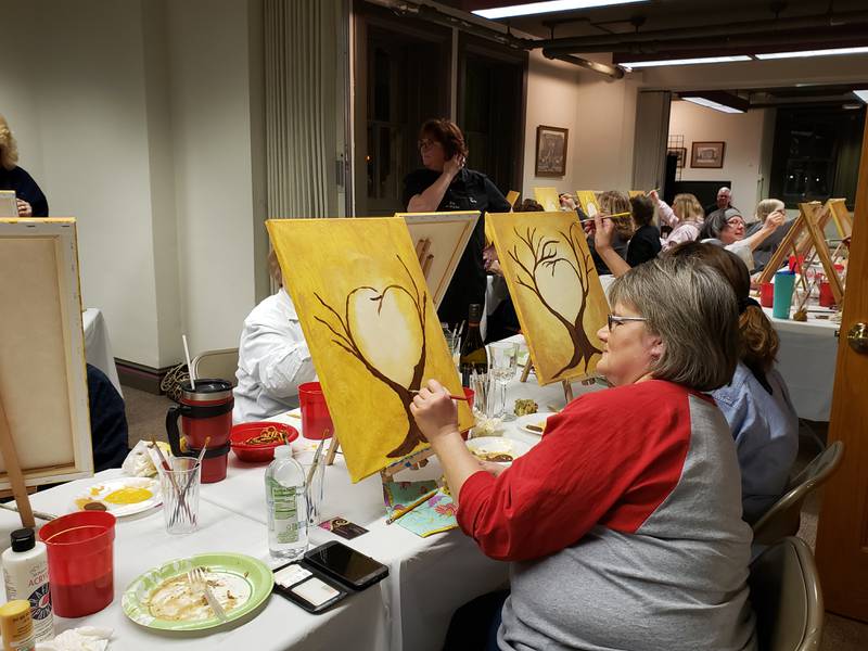 Long-time RMA volunteer and former board member Donna Nordstrom tries her hand at painting the "Tree of Life" at a party hosted by Lori McCarter at the Reddick Mansion in 2019. McCarter is returning to host another party on April 15, 2023, where participants will make a spring door hanging.