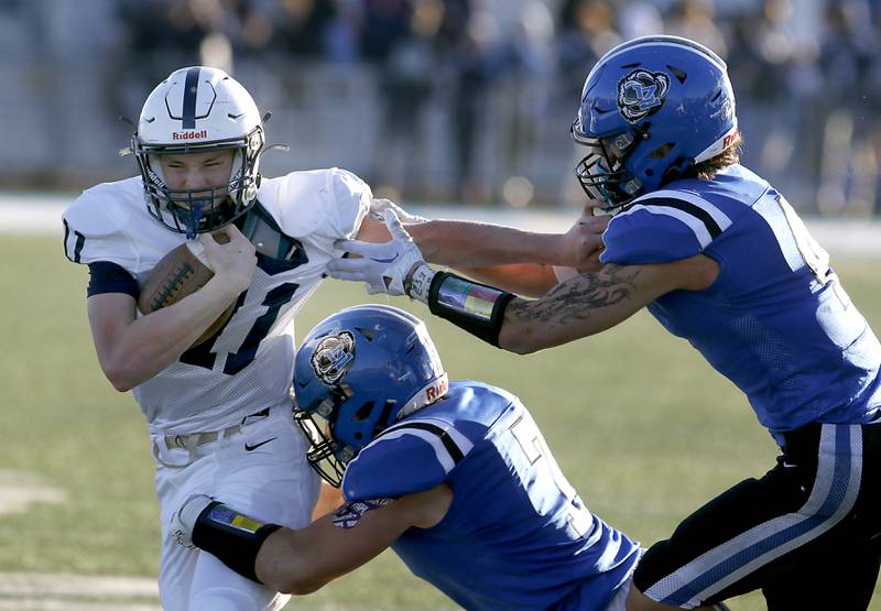 Cary-Grove's Peyton Seaburg tries tavoid the tackle of Lake Zurich's Cason Gwizdala and Nolan Siko during a IHSA Class 6A semifinal playoff football game on Saturday, Nov. 18, 2023, at Lake Zurich High School.