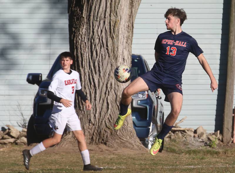 DePue/Hall's Vance Hayes leaps in the air to knock the ball down as Earlville's Colton Fruit looks on during the Class 1A Regional quarterfinal game on Wednesday, Oct. 16, 2024 in DePue.