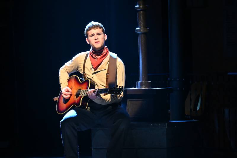 Orpheus, played by Stephen Byers, Jr., strums his guitar during rehearsals for Hadestown: Teen Edition.