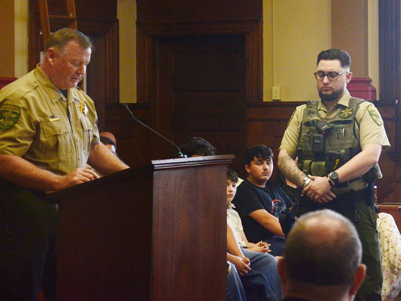 Lee County Sheriff Clay Whelan (left) speaks Thursday night about how Deputy Alejandro Castro (right) helped save the life of a single-vehicle crash victim on Feb. 12, 2026.