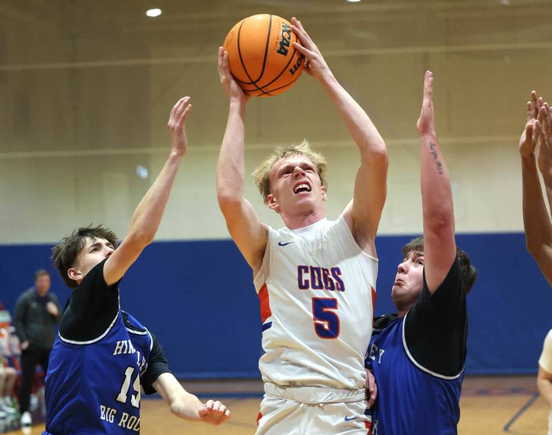 Genoa-Kingston's Blake Ides goes between Hinckley-Big Rock's Gavin Pickert (left) and Luke Badal Tuesday, Jan. 6, 2026, during their game at Genoa-Kingston High School.