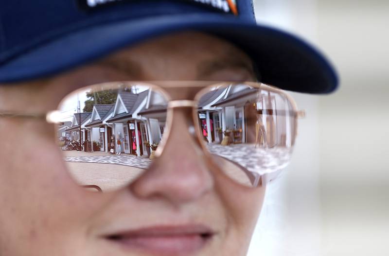 The McHenry Riverwalk Shoppes are reflected in Amy Humbracht’s glasses, on Friday, Aug.15, 2025, during McHenry’s 815 Day.