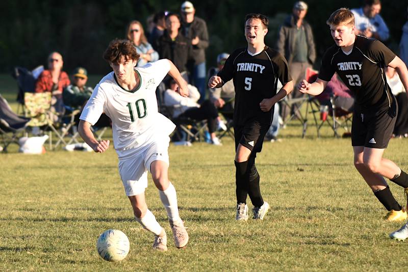 Grant Park's Sam Cordes, left, dribbles past Trinity's Ashton Bertram (5) and Jackson Wood during a game at Trinity Thursday, Oct. 9, 2025.