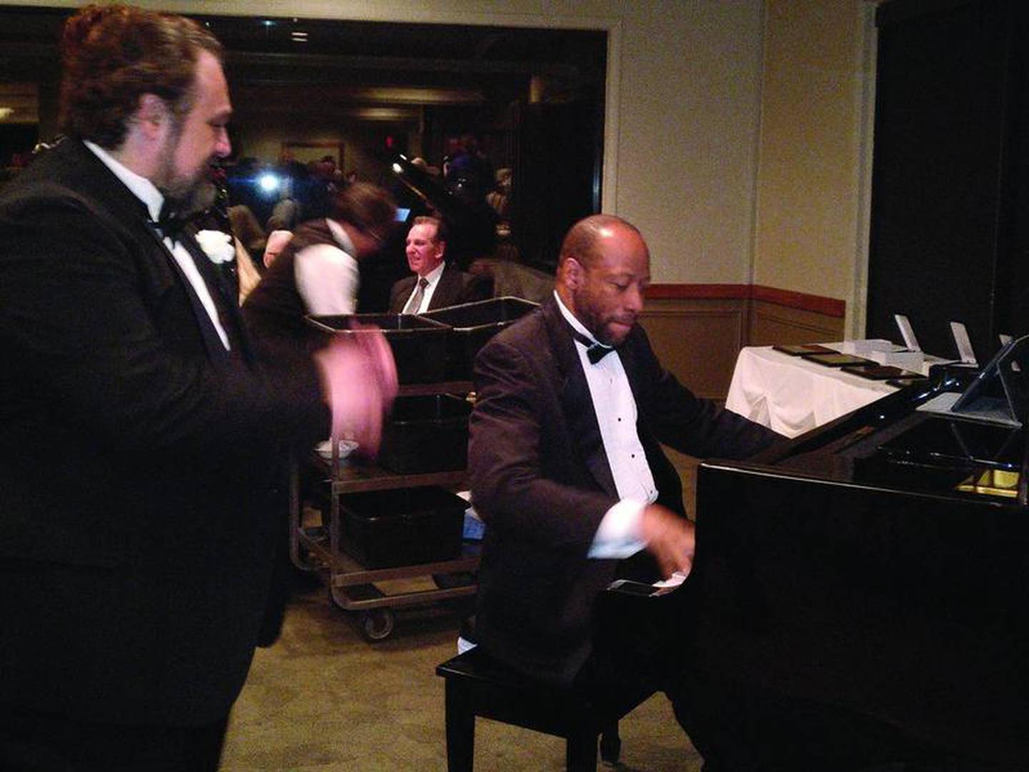 [Pianist Huntley Brown, a previous inductee in the Fox Valley Arts Hall of Fame, entertains the audience. Operatic tenor Franco Martorana (left) also performed, accompanied by pianist Murna Hansemann, a board member of the Fox Valley Arts Hall of Fame who chaired the banquet.]

"I'm just glad I had so many opportunities to financially support many organizations," said Ainsworth, long associated as a singer with area choral groups.

The second inductee was Bobbie Brown of St. Charles, a visual artist.

"I'm truly humbled to be among those you have chosen," Brown said.

She remembered a time before she had a home studio, when she painted at the dining room table. There, immersed in her art, Brown said she would lose track of time, and appreciated her husband and sons' patient understanding.