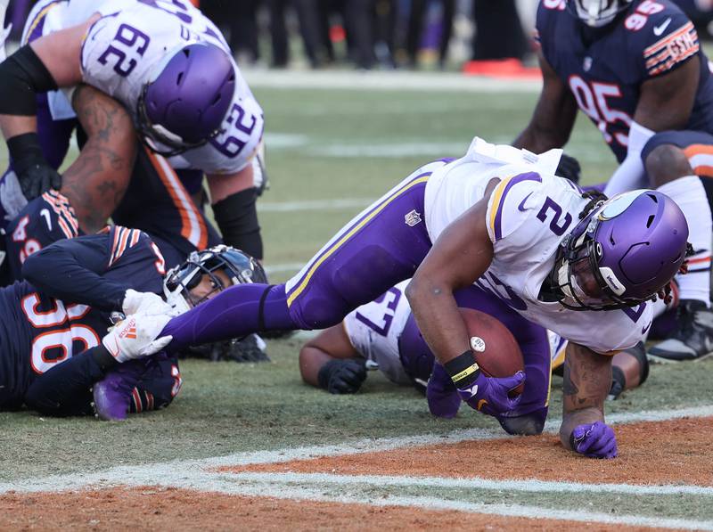 Minnesota Vikings running back Alexander Mattison scores a touchdown as Chicago Bears safety DeAndre Houston-Carson tries to hold on Sunday, Jan. 8, 2023, during their game at Soldier Field in Chicago.