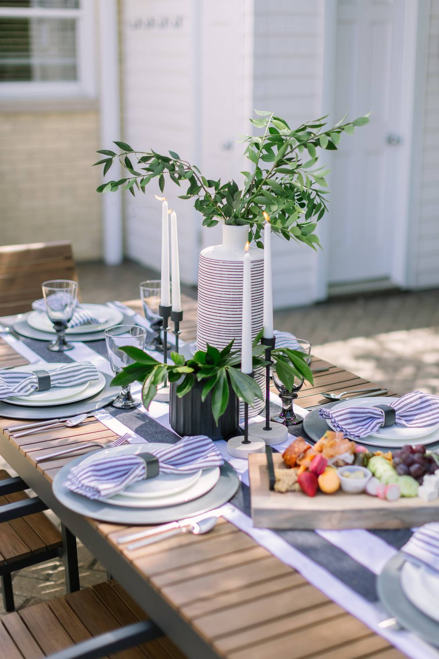 A table is decorated with plates, plants and a board of food. Yorkville Public Library will host a table scape fundraiser with 12 decorated tables on April 6 to support local charities.