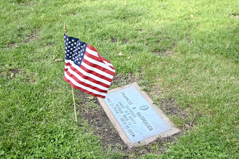 A flag flies next a veteran's grave on Thursday, May 22, 2025, at Peru City Cemetery.