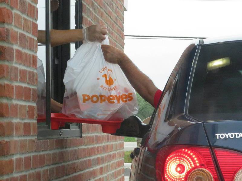 FILE PHOTO: A customer takes their drive-thru food order at about 1 p.m. Wednesday, Sept. 9, 2020, at the new Popeyes franchise location near Route 47 in Yorkville.
