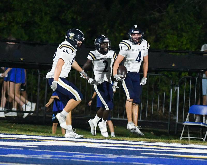 IC Catholic Prep’s Jaden Penna (4) celebrates with teammates Peter Kaczmarczyk (65) and Quai McGee (2) after Jaden scored a touchdown during the game while traveling to take on St. Francis.