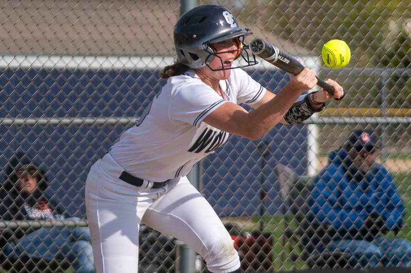 Oswego East's Finley Anderson (15) bunts the ball against Oswego during a softball game at Oswego East High School on Friday, April 21, 2023.