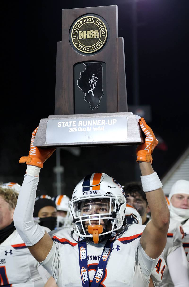 Oswego's Devin Mata holds the state runner-up trophy Wednesday, Dec. 3, 2025, after their loss to Mount Carmel in the IHSA Class 8A state chamionship game in Huskie Stadium at Northern Illinois University in DeKalb.