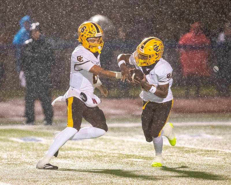 Carmel's Trae Taylor hands the ball off to Vinny Fiore against St. Charles North at the Class 7A Second Round playoff game on Saturday, Nov.8,2025 in St. Charles.