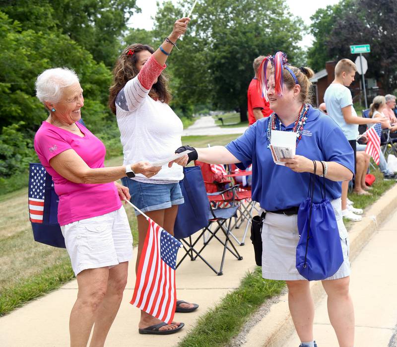 Amy Cummings of Senior Services Associates (far right) hands a flyer to a parade goer at the Yorkville Independence Day Parade on Friday, July 4, 2025.