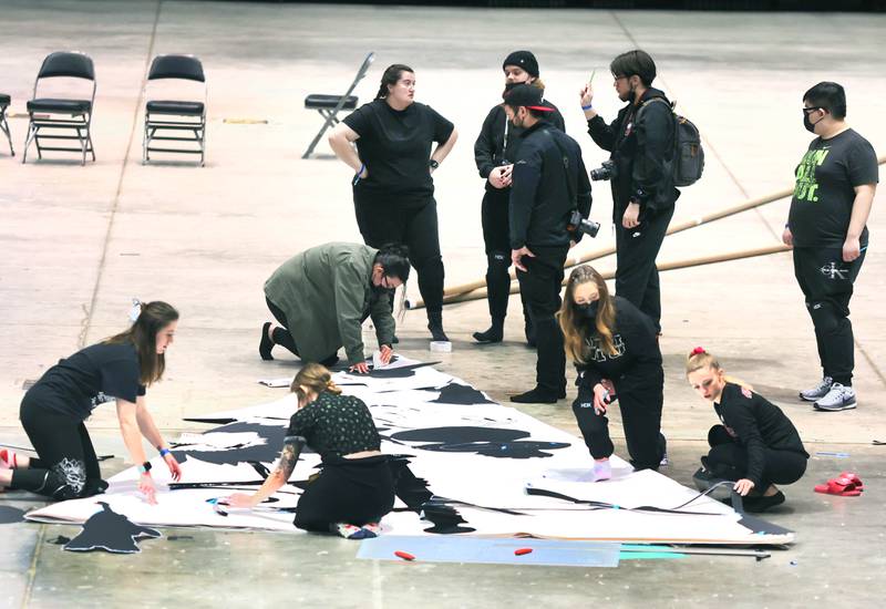 Northern Illinois University photography students work on a giant paper snowflake Tuesday, March 29, 2022, in the Convocation Center at NIU in DeKalb. The students are attempting to break the world record for the largest paper snowflake.