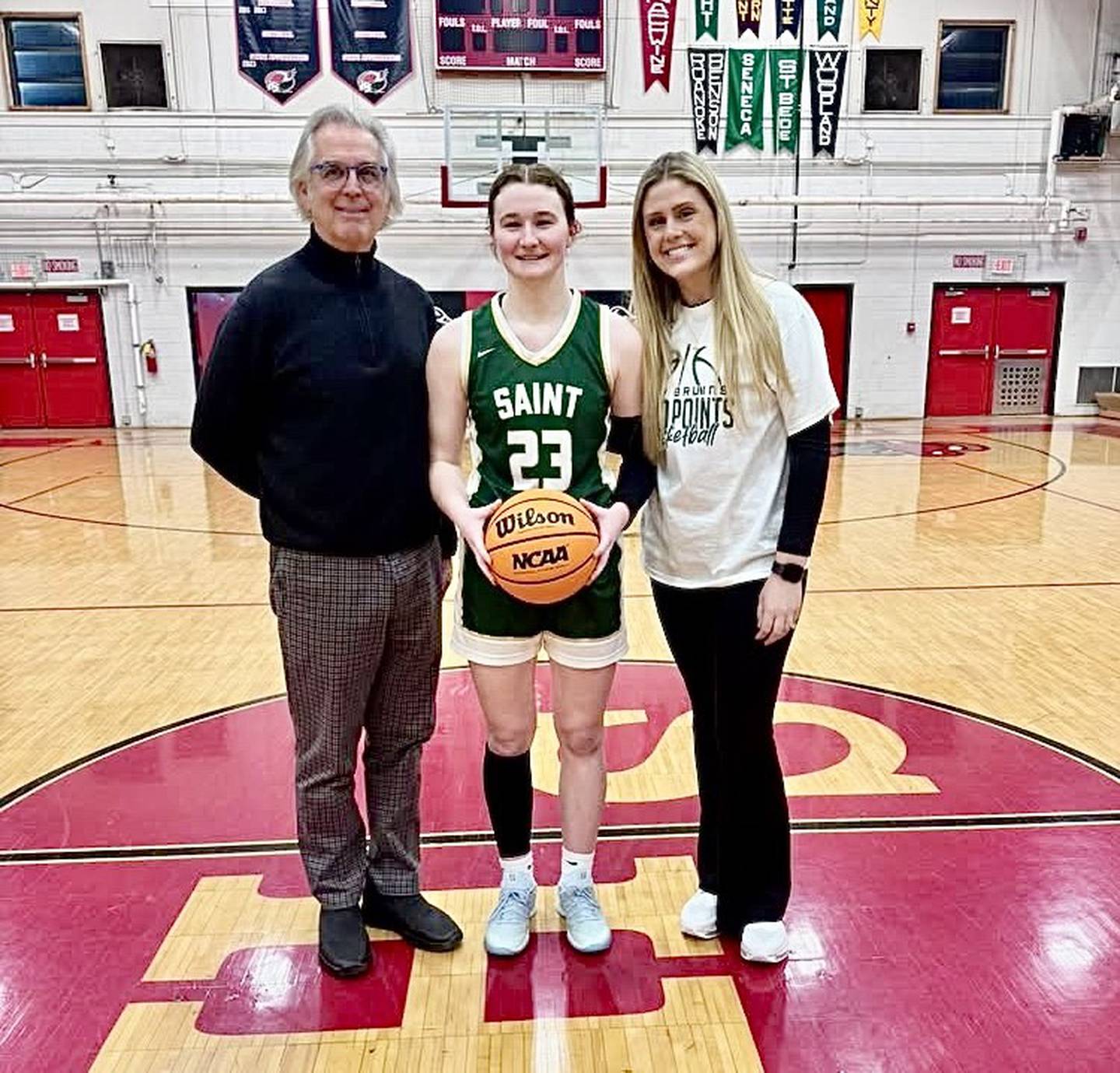 St. Bede senior Lili McClain, joined by coaches Tom Ptak and Lexi Marx, scored her 1,000th career point she scored in Thursday's game at Henry. She is the fifth St. Bede girl to score 1,000 points.