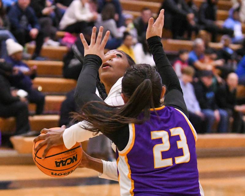 Downers Grove South's Hayven Harden (4) makes a basket while being fouled by Downers Grove North's Gianna Goodwin (23) during the game on Saturday Dec. 21, 2024, held at Downers Grove South High School.