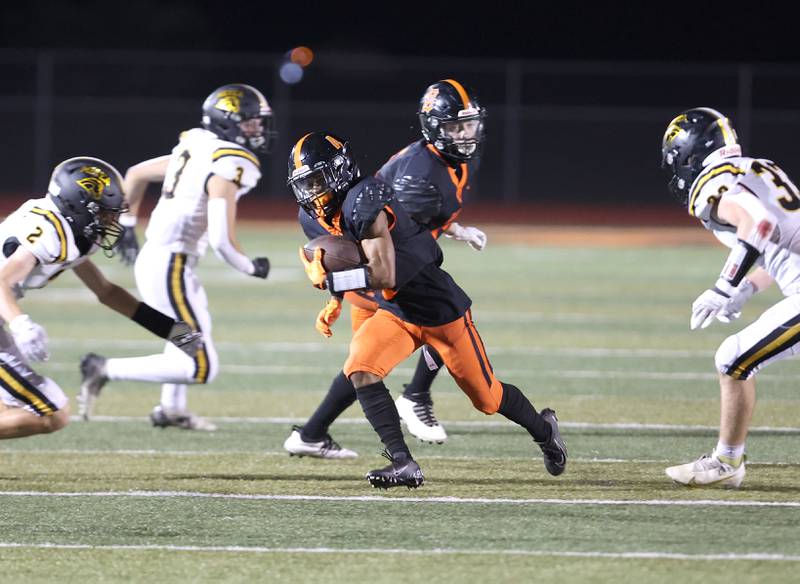 DeKalb's Xavier Dandridge splits two Metea Valley defenders after a catch during their game Friday, Sept. 16, 2022, at DeKalb High School.