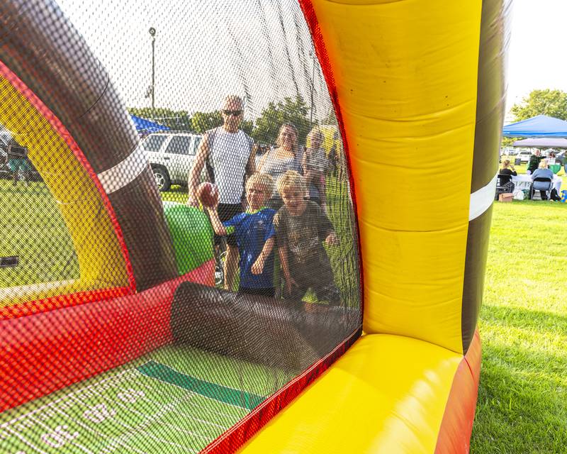 Twins Mason (L) and Cole play a football game at the Joliet Police Department's National Night Out event Tuesday, Aug 5, 2025  in Joliet.