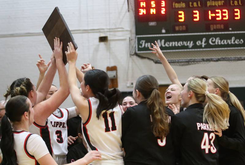 Members of the Amboy/Ohio girls basketball team hoist the Class 1A Regional championship plaque after defeating Marquette on Thursday, Feb. 20, 2025 at St. Bede Academy.
