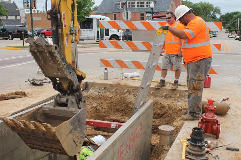 Mark Thomas, standing in the foreground, and Mark Thomas are part of a work crew that is engaged in a water main project on Thursday, July 8, 2021, along Second Street in downtown Dixon. The city of Dixon posted on its Facebook page that City Hall will remain accessible during the replacement project.