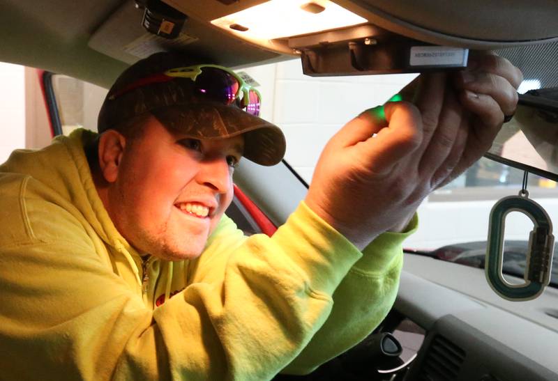 Utica firefighter Cody Dittle adjusts a HAAS Alert module inside a Utica fire truck on Wednesday, Dec. 13, 2023, at the Utica Fire Station. With HAAS Alert, Utica can send out emergency warnings to motorists on their vehicle screens, alerting them to watch for fire engines or ambulances.