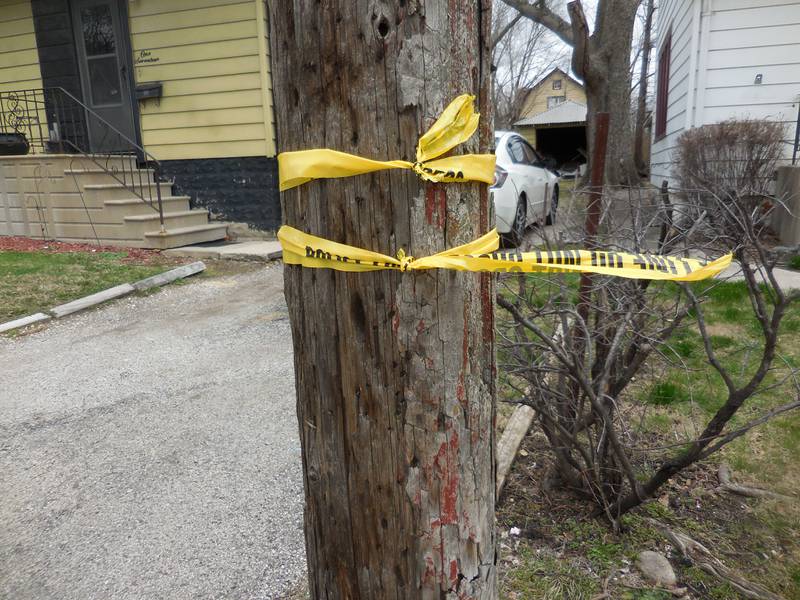 The remnants of police tape tied to a utility pole on Linden Avenue, where a Joliet police officer shot an armed man who was fleeing a traffic stop, police said.