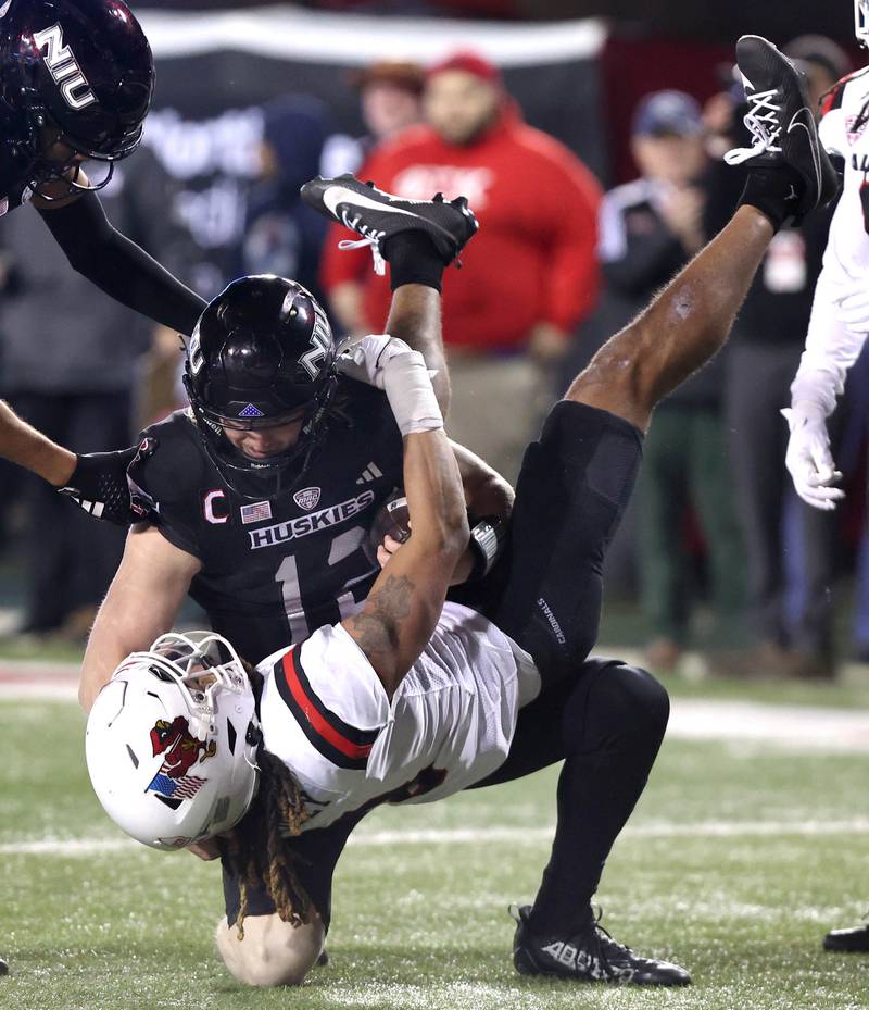 Northern Illinois' Rocky Lombardi tries to help up Ball State's Jordan Riley during their game Tuesday, Nov. 7, 2023, in Huskie Stadium at NIU in DeKalb.