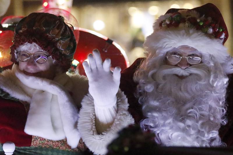 Santa and Mrs. Claus wave to children as they pass by during the annual Festival of Lights Parade on Friday, Nov. 26, 2021, in downtown Crystal Lake.