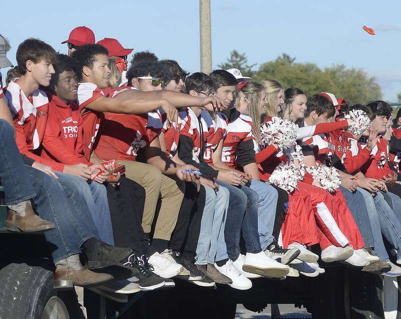 The Streator High School football team and cheerleaders toss candy to onlookers Wednesday, Sept. 28, 2022, as they make their way down Main Street during the school’s homecoming parade.