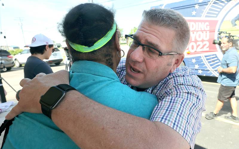 Darren Bailey, a Republican candidate for Illinois governor, gets a hug from a supporter Friday, June 17, 2022, during his campaign stop at Tom and Jerry's in Sycamore. Bailey is currently on a bus tour across the state that will cover 102 countys in 14 days.
