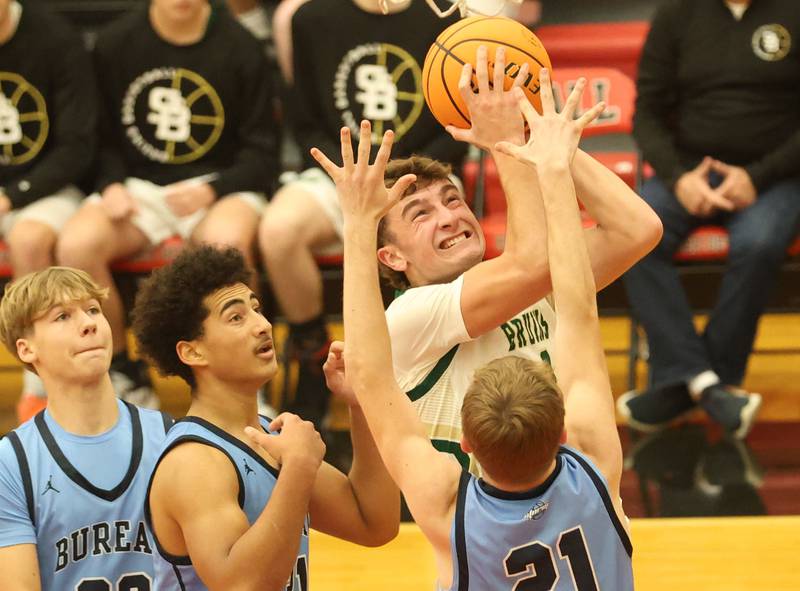 St. Bede's Gino Ferrari eyes the hoop after getting by three Bureau Valley defenders (from left) Marek Johnson, Dakarai Martin and Zac Wiggim during the Colmone Classic on Thursday, Dec. 11, 2025 at Hall High School.