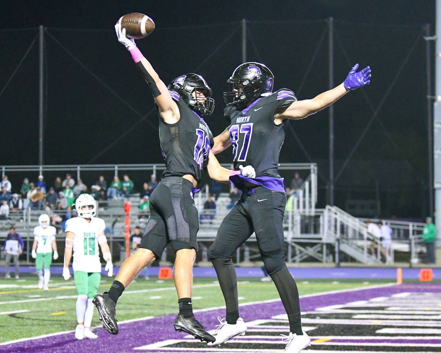 Downers Grove North's Oliver Thulin, left, celebrates with teammate Jacob Vroman (87) after Oliver scores a touchdown on Friday Oct. 10, 2025, while taking on York High school at Downers Grove North High School.