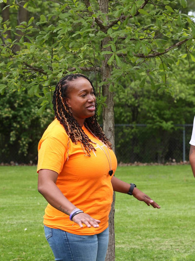 Andrea Elion, mother of Ezra Hill Jr. talks Monday, May 12, 2025, about him as she stands next to a tree and rock garden at Tyler Elementary School, where he attended, that is dedicated to his memory. Hill was murdered in 2019 in Harvey, and the Fifth Annual Ezra Hill Jr. Memorial Rock Painting event will be held on June 7 at the school in DeKalb.