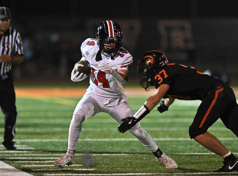 Lincoln-Way Central's Nica Bartkus (14) tries to elude Lincoln-Way West's Nicholas Elstner (37) during the conference game on Friday, SEP. 19, 2025, at New Lenox.