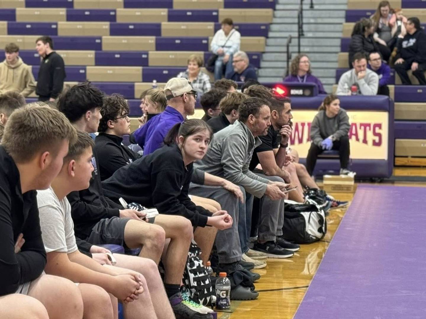Wilmington wrestling coach Nick Dziuban, right of center, coaches a match alongside fellow coaches and Wilmington wrestlers.