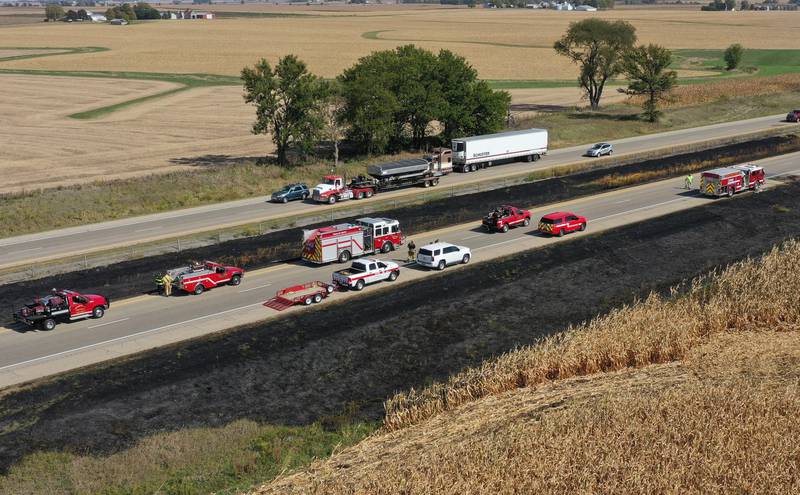 Firefighters extinguish a brushfire on Wednesday, Oct. 9, 2024 along Interstate 80 in the eastbound lane near mile post 65 in Bureau County.  A MABAS box alarm was sent out around 11:45 a.m. and upgraded to a fourth-alarm. Interstate 80 was shut down in the Eastbound lane while firefighters doused the flames. Fire companies from Utica, Oglesby, Ladd, Bureau, Hennepin, Peru, La Salle, Spring Valley and others responded to the scene.