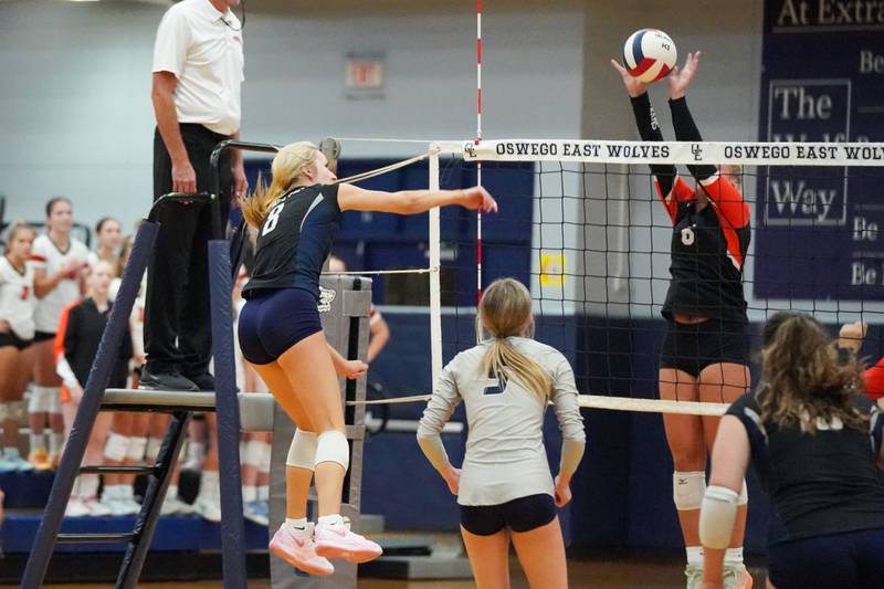 Minooka's Kendall Kozak (right) blocks a kill attempt by Oswego East's Tori Vlcek (8) during a Southwest Prairie Conference match in Oswego on Thursday, Sept. 18, 2025.