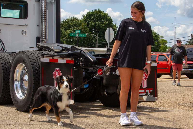 Women walks dog on Saturday, July 20, 2024 at the Convoy Against Cancer Big Truck Show on Main Avenue in Ladd.