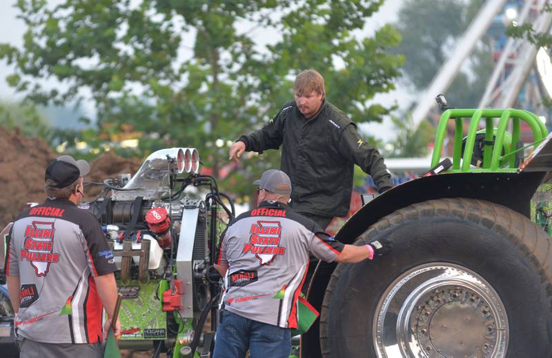Logan Dornbush of Albany talks to Illini State Pullers officials after making a run in his modified tractor "Joker" in the open division of the tractor pull at the Ogle County Fair in Oregon on Thursday, July 31, 2025.