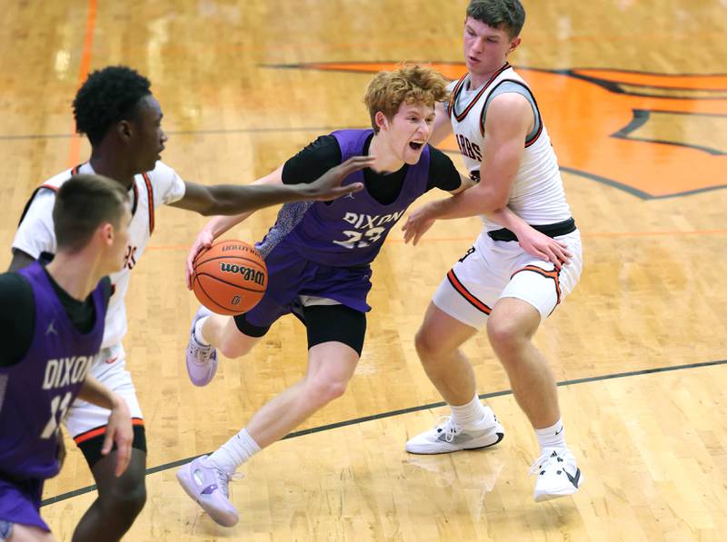 Dixon’s Austin Hicks tries to drive by DeKalb’s Eric Rosenow during their game Tuesday, Dec. 12, 2023, at DeKalb High School.