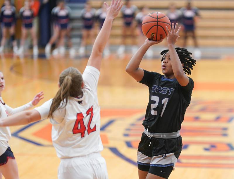 Oswego East's Desiree Merritt (21) shoots the ball in the post over Oswego’s Kendall Grant (42) during a basketball game at Oswego High School on Tuesday, Dec 12, 2023.