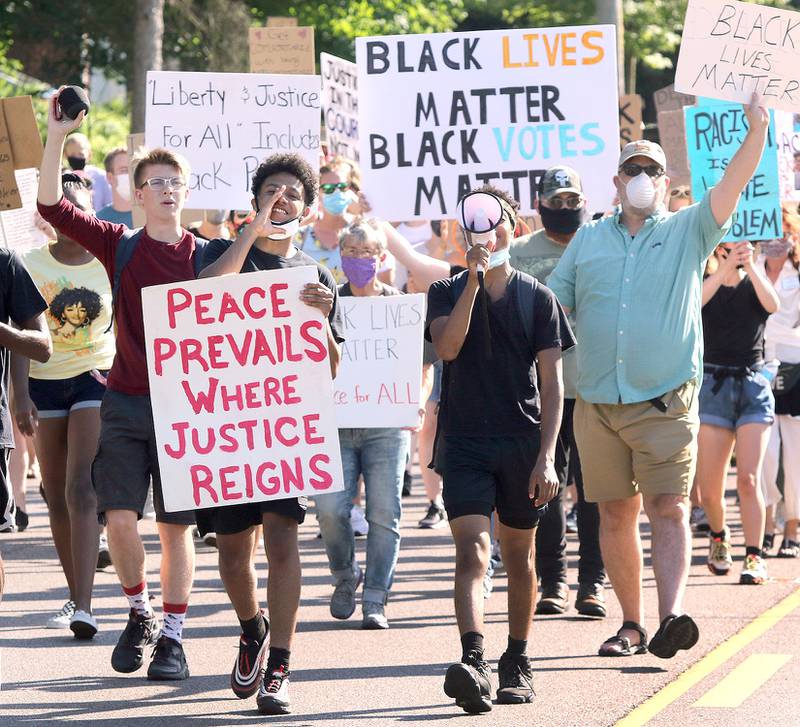 Participants head north on Sycamore Road Friday during the Juneteenth Freedom March. The event, organized by local Black Lives Matter leaders, stepped off at Clinton Rosette Middle School and concluded at Hopkins Park in DeKalb. Juneteenth is celebration commemorating the liberation of slaves in the United States.